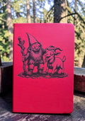 The Gnomie Field Journal - red notebook featuring Gnomie and Goat illustration