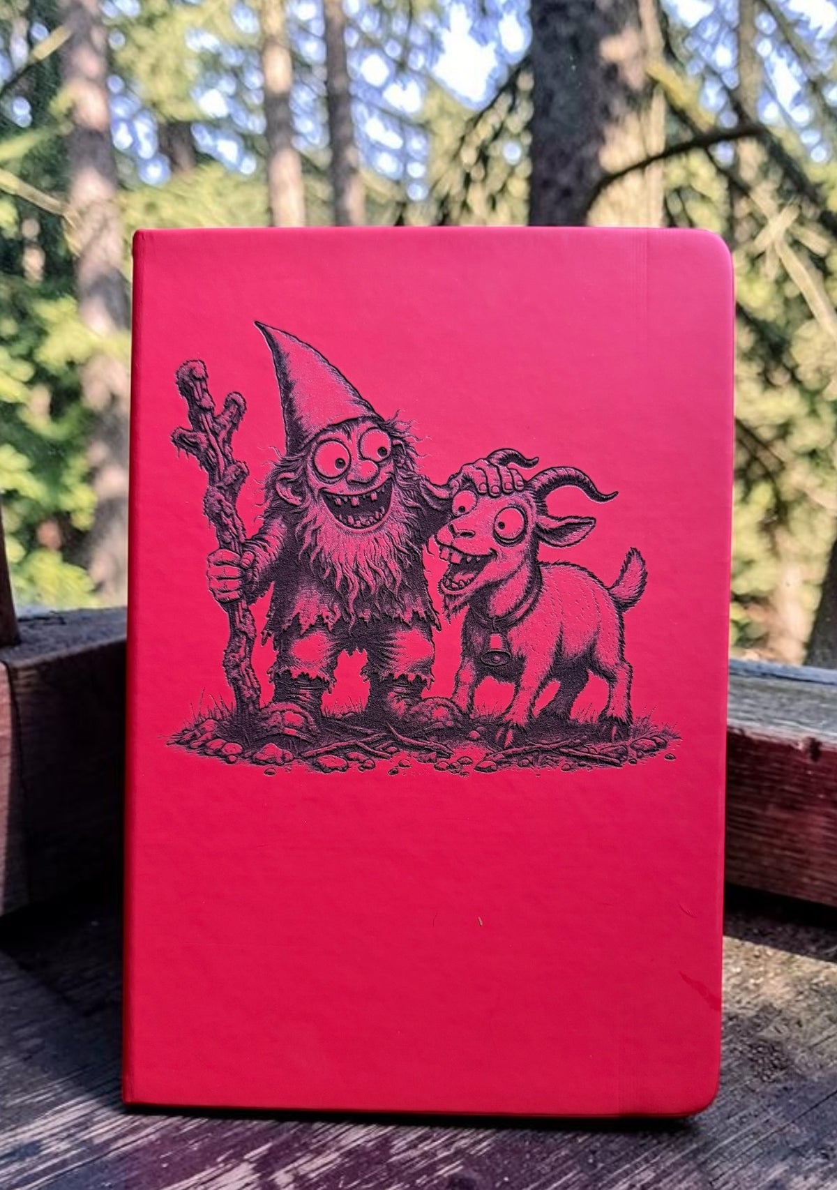 The Gnomie Field Journal - red notebook featuring Gnomie and Goat illustration